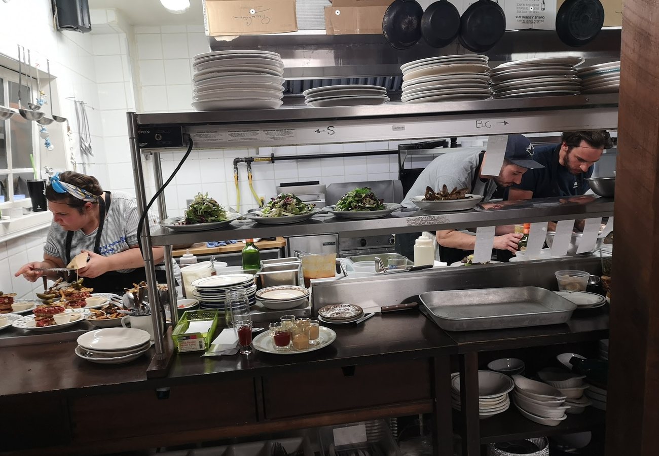 La cuisine ouverte pendant le service, les cuisiniers en train de dresser les assiettes