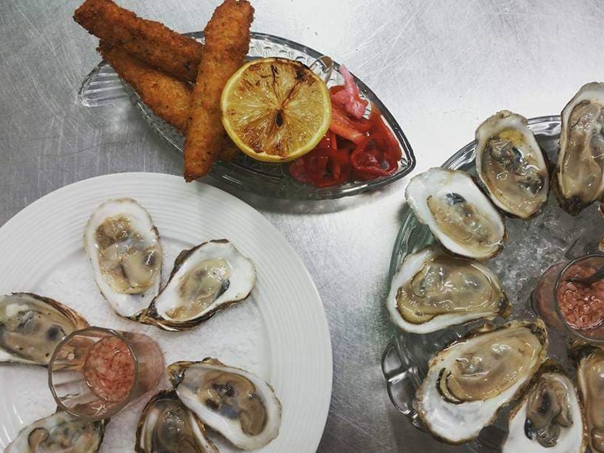 Un plateau d'huîtres et de beignets de poisson, avec un demi-citron grillé